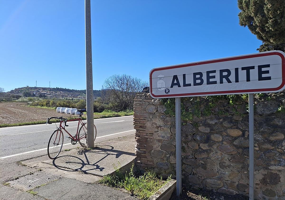 Una bicicleta, junto al cartel de entrada de Alberite, a pie de la LR-255, por donde transcurrirá el carril ciclopeatonal.