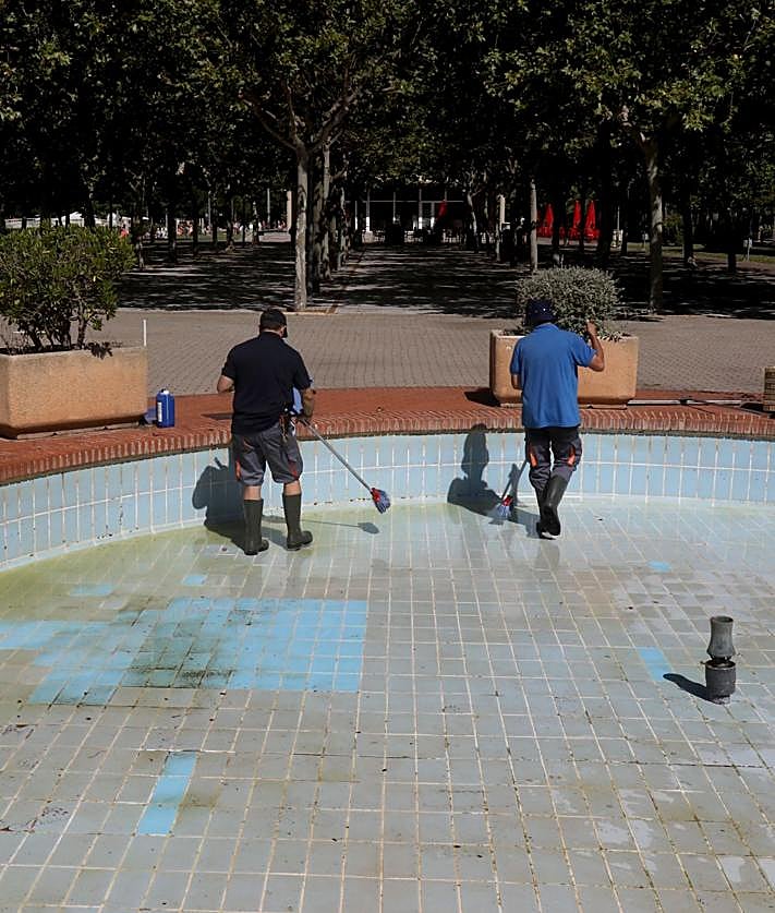 Imagen secundaria 2 - Tres imágenes del estado de la instalación. En una se ve uno de los árboles derribados por la dana, en otra, el estado del césped. En la última, dos empleados limpian una de las fuentes del complejo. 