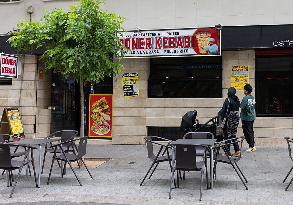 Una pareja observa el cartel de uno de los nuevos kebabs recién abiertos en Logroño.