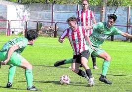 Carlos Benítez maniobra entre dos jugadores del Náxara.