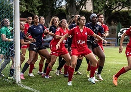 Las jugadoras del DUX se colocan en el área del AEM para rematar un córner.