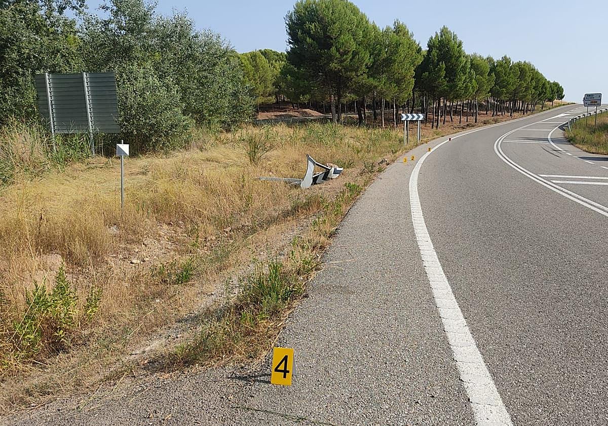 Imagen principal - El coche siguió recto en la curva, se salió rompiendo las señales y cayó al barranco ya por detrás del vallado protector.