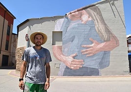 Taquen, uno de los artistas de Bañarte, ante el mural que años atrás pintó en Pradejón.