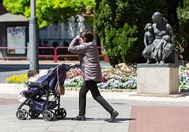 Una mujer empuja un carrito de bebé por Logroño.