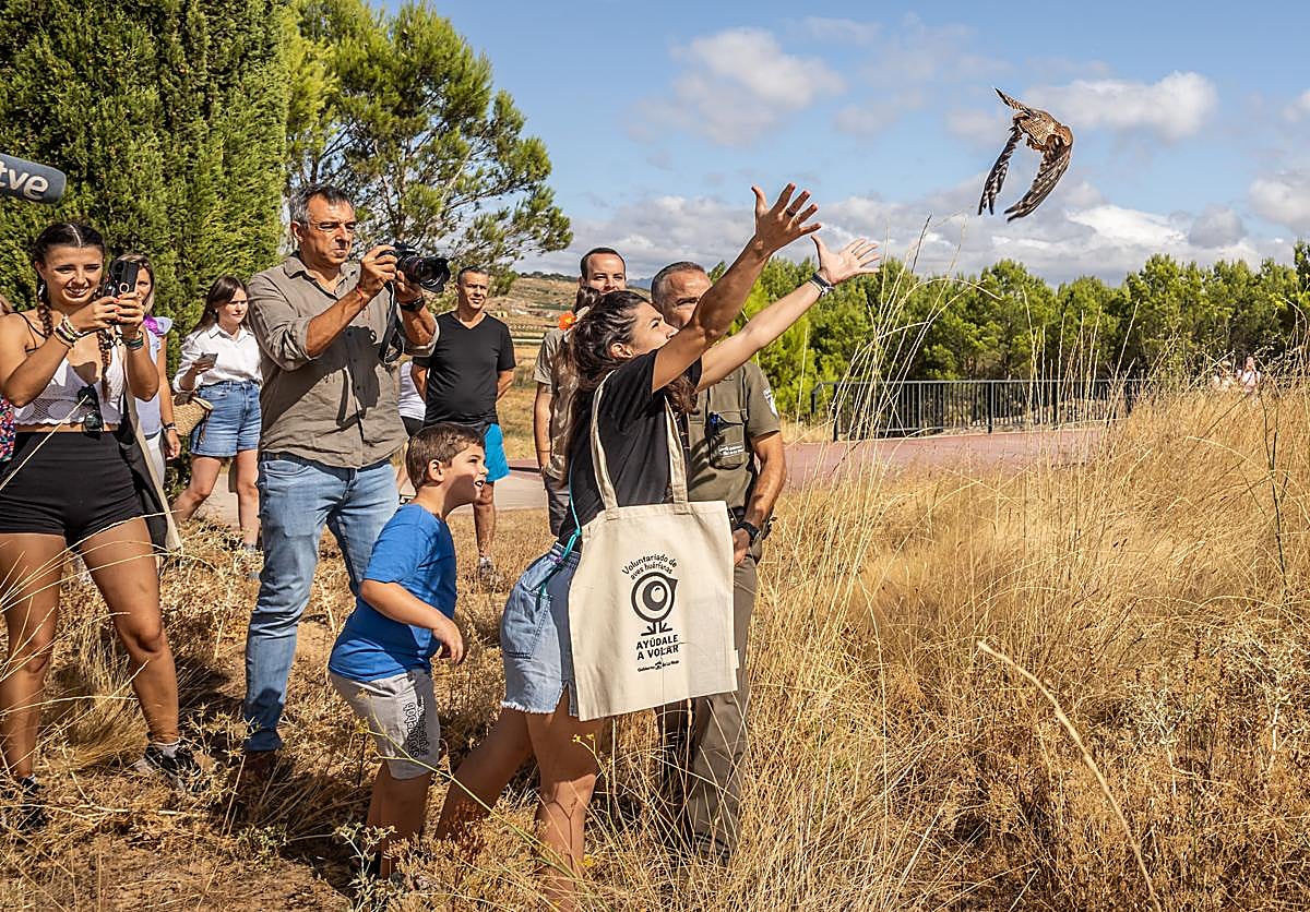 Una de las voluntarias suelta un ave en el parque de La Grajera.