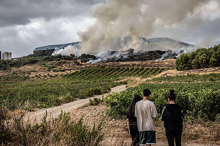 Unos jóvenes contemplan el incendio en la tarde del miércoles.