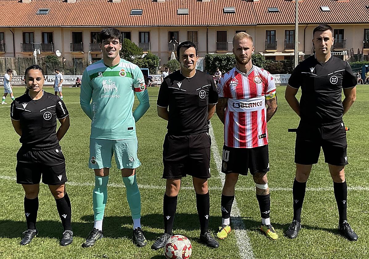 Los dos capitanes posan con el trío arbitral al inicio del encuentro.