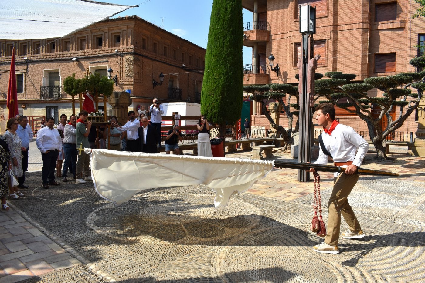 Ignacio Ruiz, con el pendón frente a la imagen del Niño Jesús al llegar la procesión al fosal en Aldeanueva de Ebro.