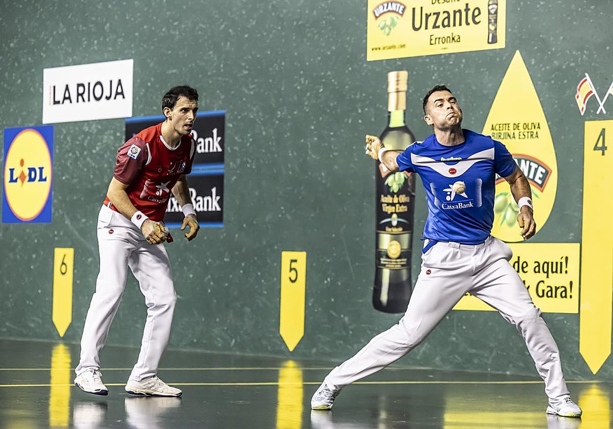 Jaka golpea la pelota mientras Altuna observa la acción.