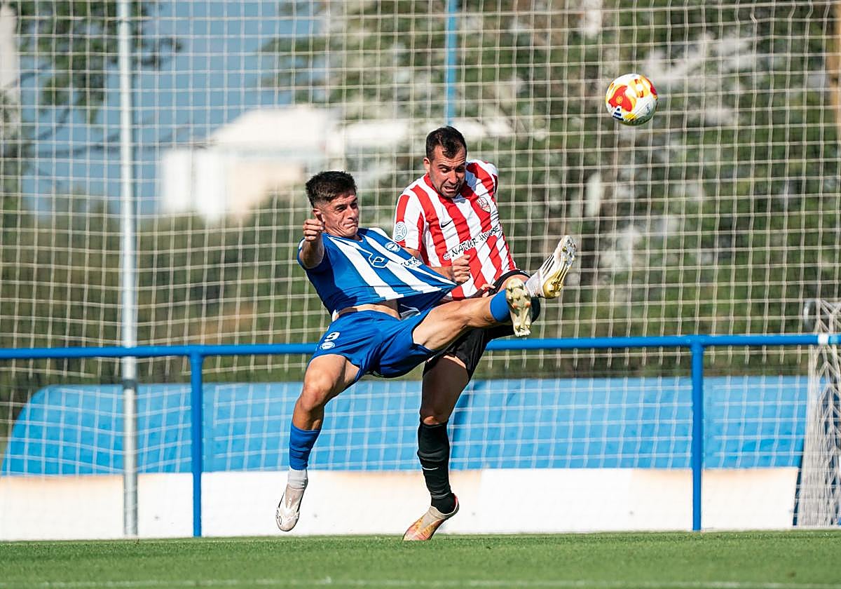 Edu Cabetas despeja el balón en pugna con Aimar, jugador del Alavés B.