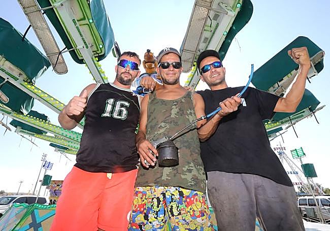 Trabajadores ponen a punto una de las atracciones de la feria.