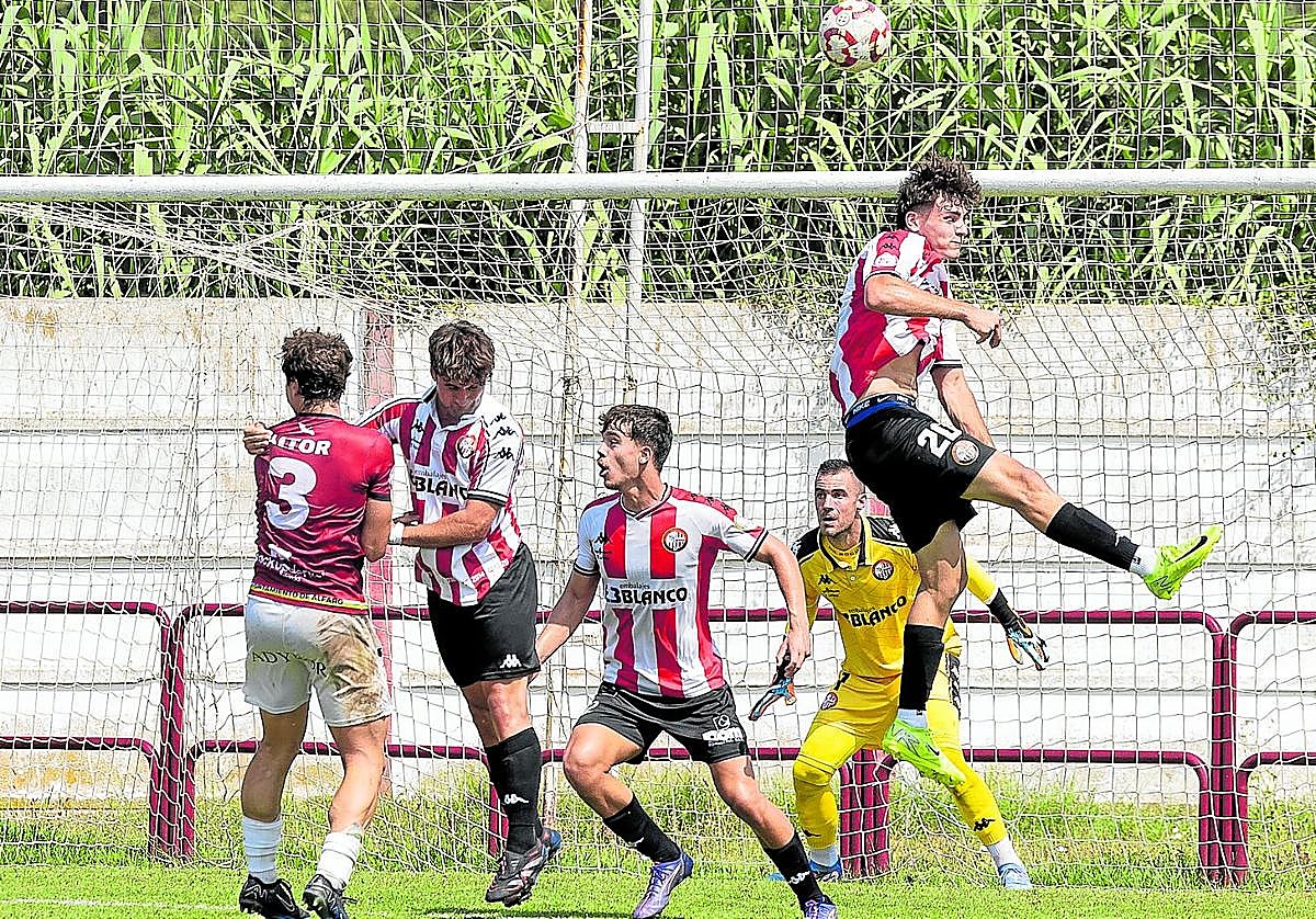 La defensa de la SD Logroñés despeja un balón aéreo mientras Kike Royo observa la jugada ante el Alfaro en pretemporada.