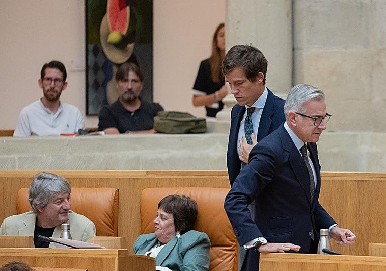 Alacid, de pie, se dirige a su escaño, situado junto al de Henar Moreno