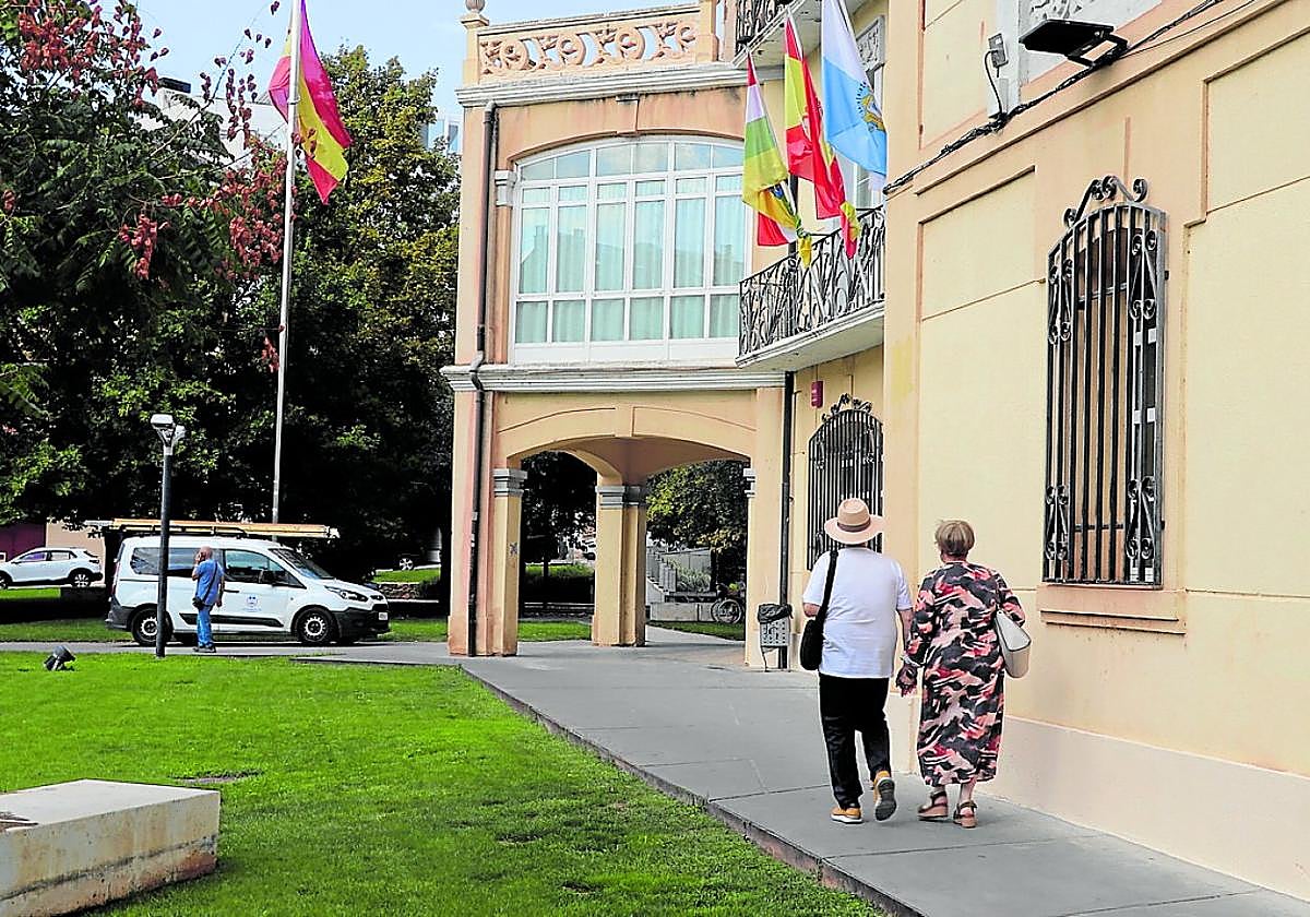 Una pareja pasea ante el bar de La Baronesa, con un vehículo de la brigada de obras en su entrada.