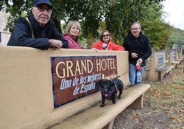 Unos turistas catalanes observan uno de los bancos de Pradillo, al que se sube su perro Matías.