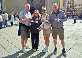Los cuatro británicos, con su pincho de choricillo y panceta y sus botellas de vino.