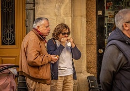 Una pareja degusta el pincho solidario de Cáritas.