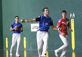Darío golpea la pelota con Iztueta y Rezusta mirando desde atrás.