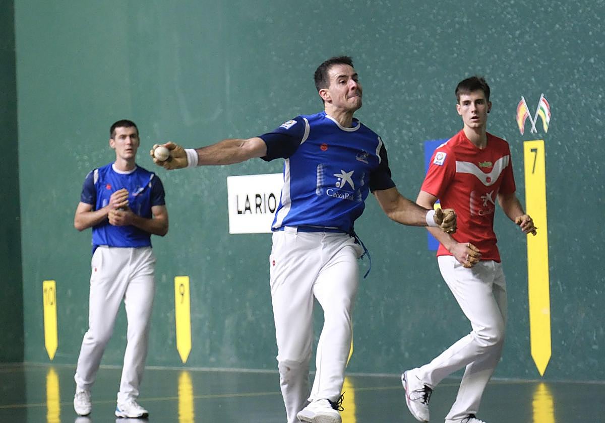 Darío golpea la pelota con Iztueta y Rezusta mirando desde atrás.