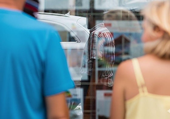 Clientes ante el escaparate de una inmobiliaria