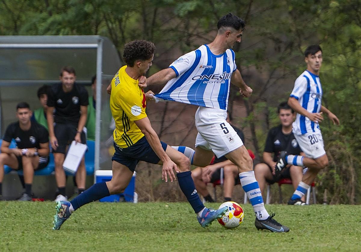 Un jugador del Ebro agarra a Juan en el primer partido del curso.