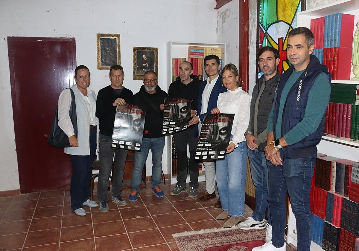 Los asistentes a la presentación del recorrido sujetando el cartel de esta edición titulada 'Sin salida'.