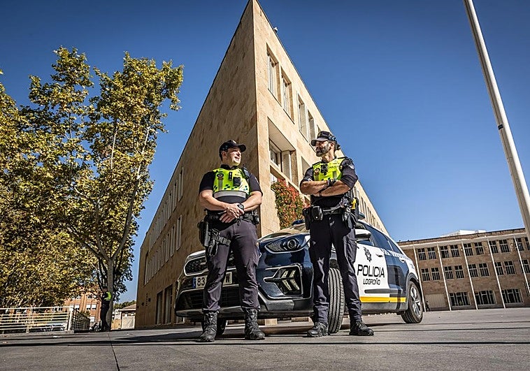 David Aldana e Indortes Pascual-Salcedo, los dos agentes reconocidos, en el Ayuntamiento, junto a un vehículo policial.