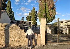 Un hombre observa los desperfectos ocasionados en el muro de entrada al cementerio.