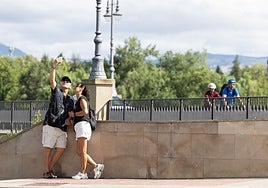 Una pareja de turistas se tira un selfi en el Puente de Piedra de Logroño.