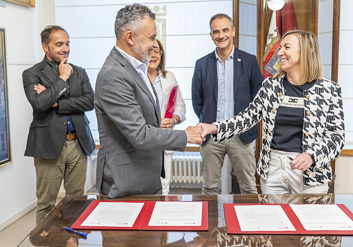 Conrado Escobar y Eva Sanz se saludan tras la firma del convenio en presencia de Eduardo Fonseca, Cristina Olarte y Miguel Sainz.