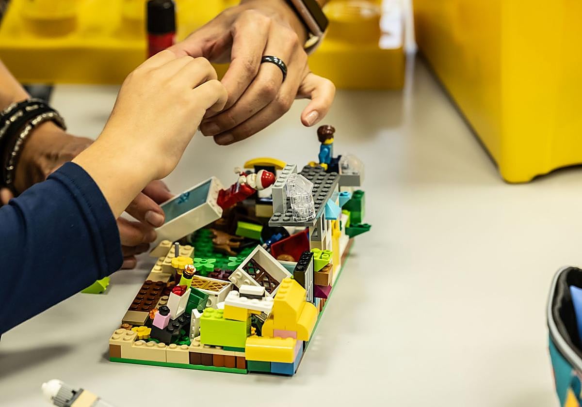 Un alumno juega con una figura Lego.