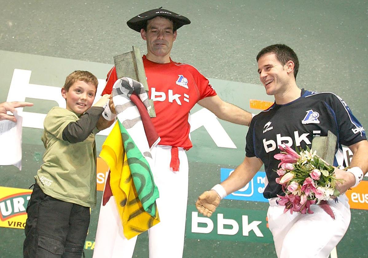 Titín, con la chapela y la bandera de La Rioja, en el podio con Barriola.
