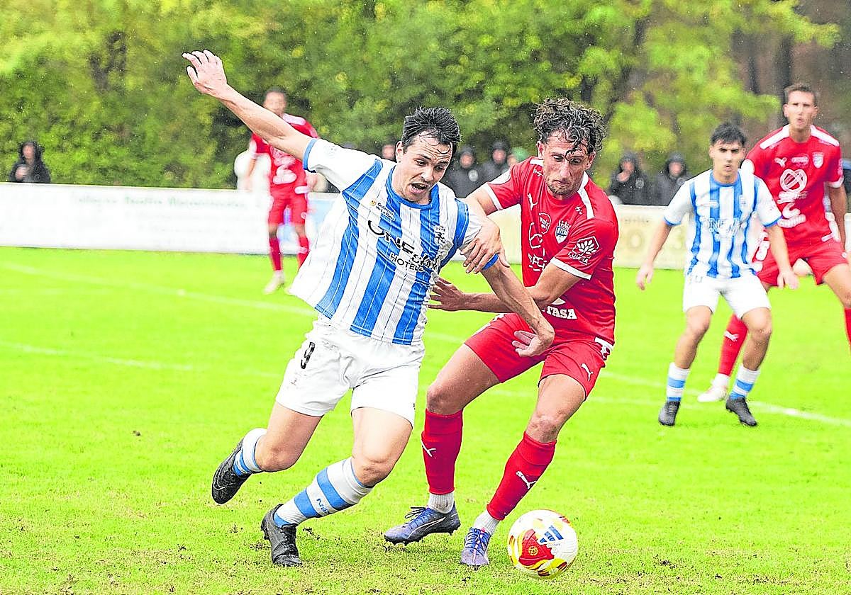 Orodea y Meseguer intentan hacerse con el dominio del balón en el partido entre Náxara y Utebo en La Salera.