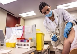 Una enfermera administra las dosis frente a gripe y covid a un paciente en el centro de salud de Cascajos.