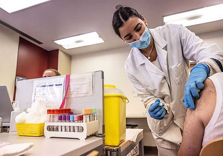 Una enfermera administra las dosis frente a gripe y covid a un paciente en el centro de salud de Cascajos.