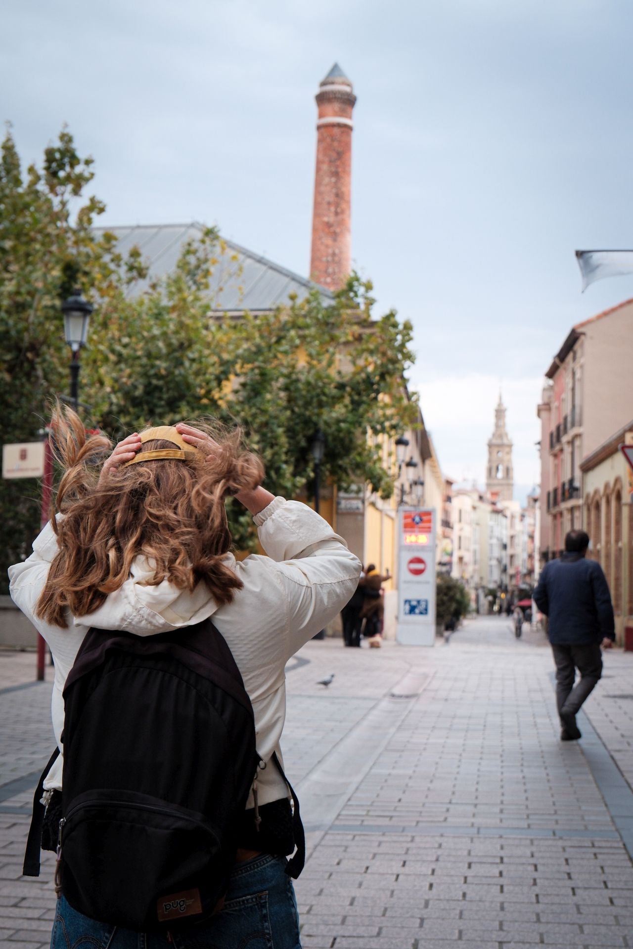 Una mujer se sujeta la gorra para que no se la lleve el viento en Logroño.