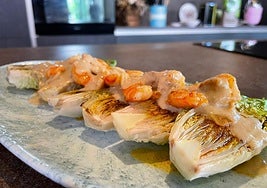 Una fuente con los cogollos a la plancha y sus langostinos al ajillo.