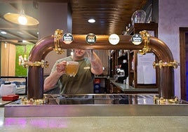 Un camarero sirve una caña de Estrella Galicia.