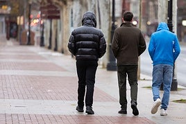 Tres jóvenes pasean abrigados por las calles de Logroño.