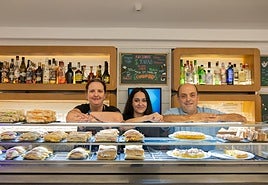 Carlos Belaza posa frente a su nutrida barra matinal, junto a la cocinera y a una de las camareras del Génesis.