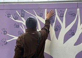 Uno de los padres participa en el mural poniendo su mano.