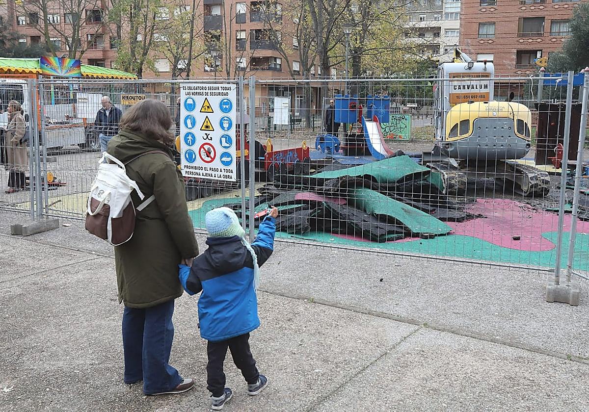 Un niño observa a la maquina levantar el suelo del parque.