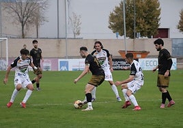 El alfareño Arturo Fernández, uno de los goleadores del pasado domingo, toca entre la defensa del Tudelano y el apoyo de varios compañeros.