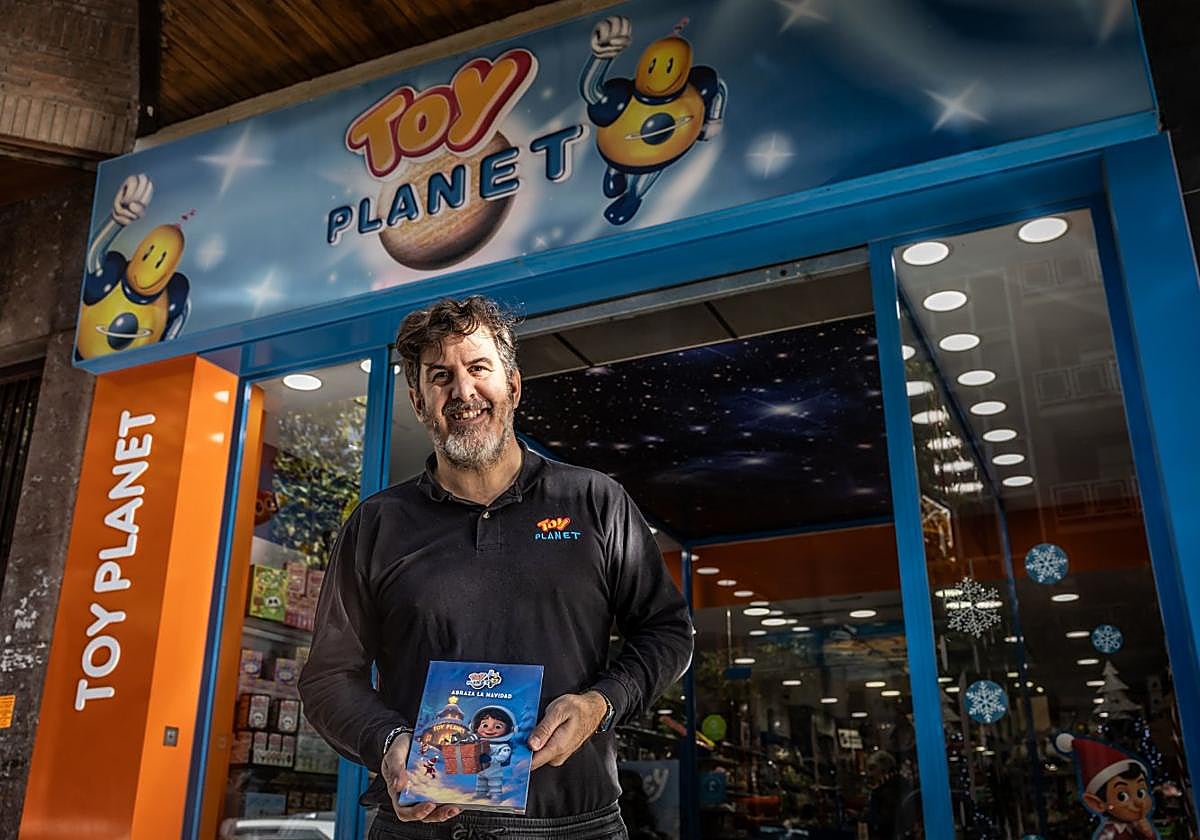 Rodrigo posa delante de su juguetería con el catálogo de artículos para esta campaña.