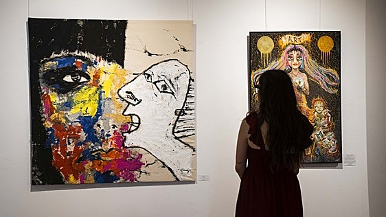 Visitante ante dos de los lienzos de la exposición 'Grietas'.