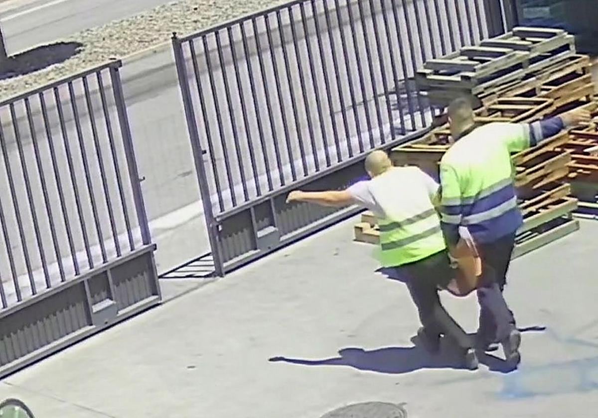 Los detenidos salen de la fábrica con el materia..