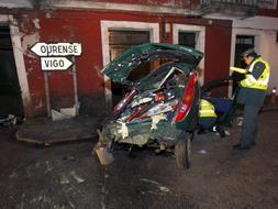 Un agente de la Guardia Civil, junto al vehículo siniestrado. / Efe