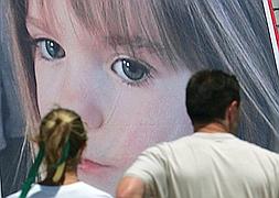 Los padres de Maddie ante un cartel con su cara. / Archivo