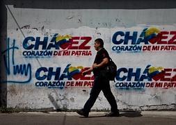 Un hombre pasa delante de una pared con pintadas alusivas a Chávez. / Efe