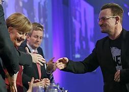 Bono, vocalista de la banda irlandesa U2, saluda a la canciller Merkel. / Juanjo Martín (Efe) | Vídeo: Atlas